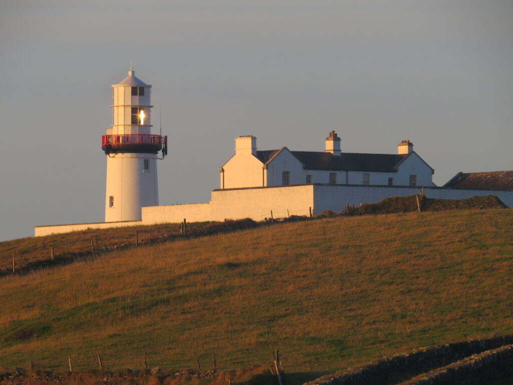 Golden hour light shining on Galley Head Lighthouse, Co. Cork