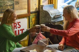 Two women clinking glasses at an Irish traditional pub